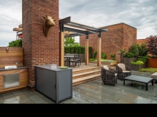 The design integrates existing brick chimneys and elevator penthouse as organizing elements for the garden composition with an arbour visually connecting disparate architectural elements.