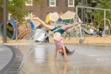 A playful and interactive set of arcing water jets activate the children's play area located in the east precinct of the site.