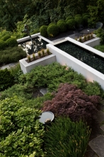 The strong rectilinear lines of the modernist concrete pool contrast with the soft textural plantings. Intimate seating areas provide spaces for dining and reflection.