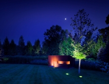 Accent lighting of the specimen trees and custom folly unifies the outdoor stage for this special playful setting.