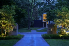 Sacred geometry proportions, cut into reclaimed stone pillars, calm the eye while framing the “borrowed” landscape of the sculptural Modernist house beyond – a gift for those departing.