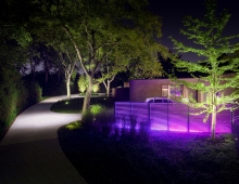 The entry drive leads to the formal entry loop beyond, announced through a change in paving module, with family parking made distinct through the changing colors of the lighting screen.