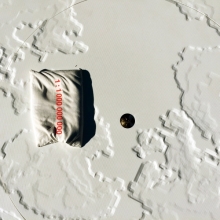 Detail view of the kneeling pad and survey stake at the center of the exhibition
