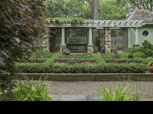 A pergola and twin summer houses, constructed from salvaged materials from an adjacent historic house too deteriorated to restore, anchor sunken garden and lend visual continuity.